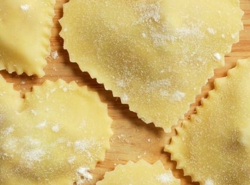 Heart-shaped ravioli arranged on a wooden surface.